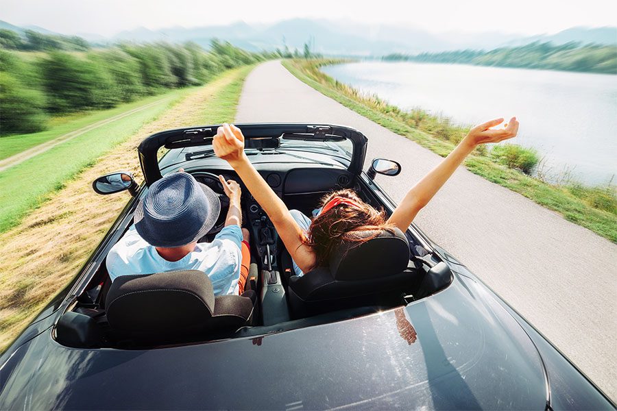 Insurance Quote - Joyful Young Couple Enjoying Their Road Trip in Their Convertible Through the Countryside on a Sunny Summer Afternoon