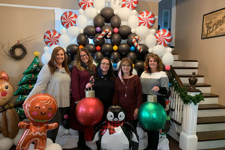 Amazing Feedback - Portrait of Helwig Insurance Agency Team Members Standing Next to Christmas Decorations and Balloons in the Office