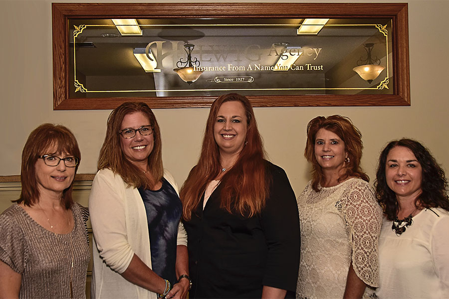 Meet Our Team - Portrait of Helwig Insurance Agency Team Members Standing in Front of a Helwig Agency Plaque on the Wall